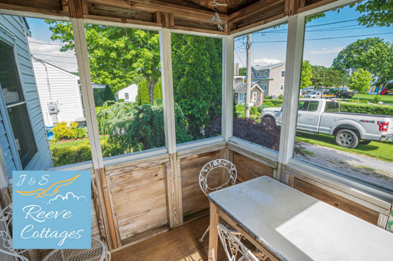 Cozy Waterfront Cottage 6 Screened-In Porch on a perfect day viewing the beautiful gardens